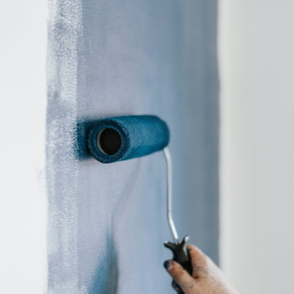 Brushes & RollersA close-up of a paint roller painting a wall blue.