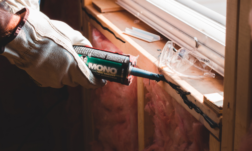 Caulk being applied to a window sill.