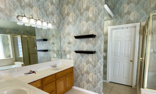 A bathroom with walls covered with patterned wallpaper.